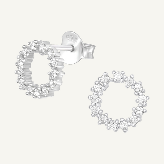 A pair of silver ear studs with cubic zirconia stones, designed with a circular openwork pattern.